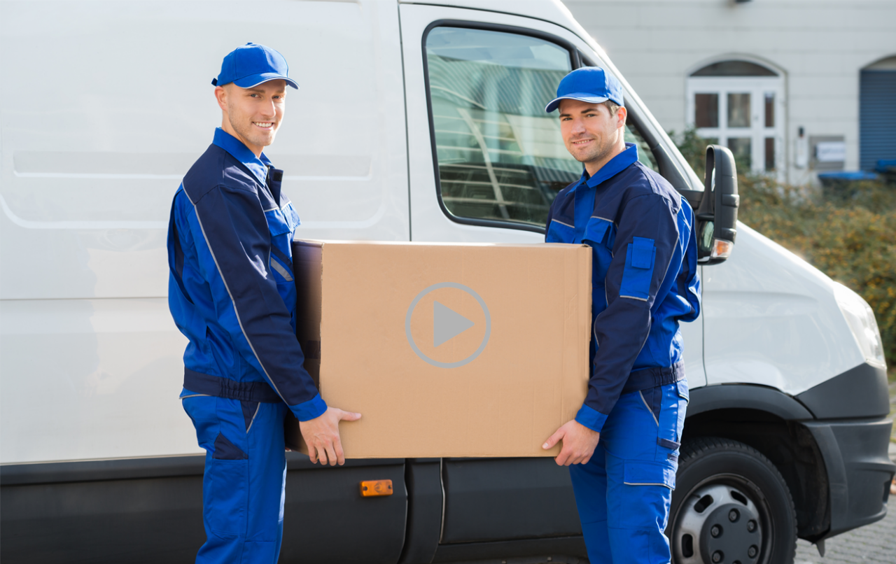 Two men holding moving boxes in front of a moving truck