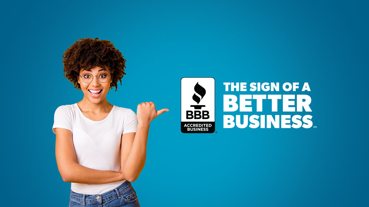lady smiling pointing to sign of a better business bbb seal