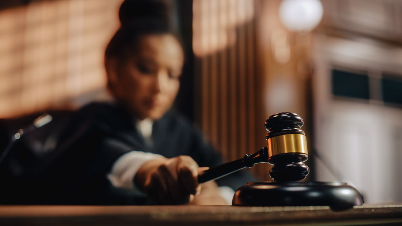 Court of Law Trial in Session: Honorable Female Judge Pronouncing Sentence, striking Gavel. Focus on Mallet, Hammer. Cinematic Shot of Dramatic Not Guilty Verdict. Close-up Shot.