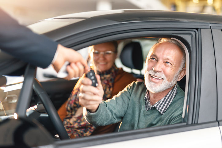 Happy senior couple buying a car.