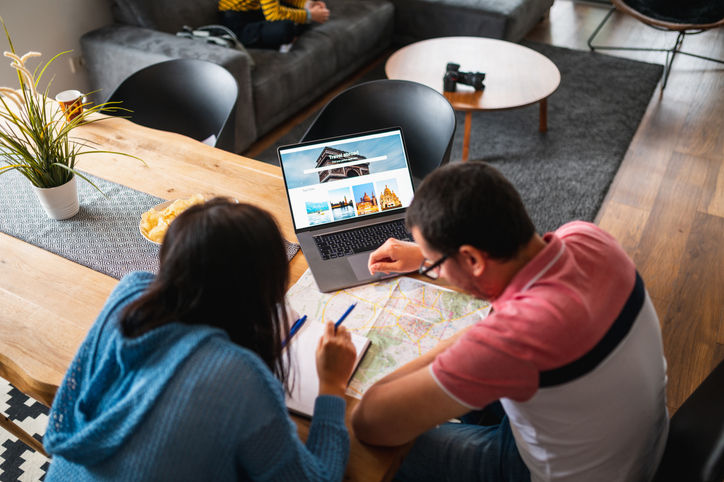 Heterosexual Couple Planning A Vacation Together Using Laptop