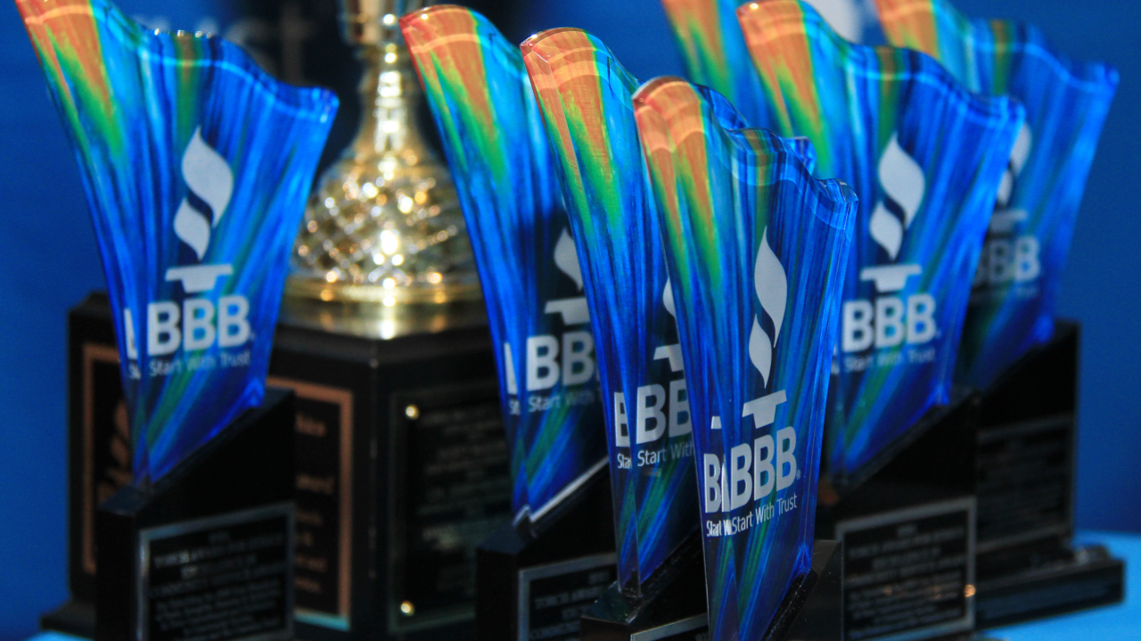 Cropped shot of two corporate businesspeople applauding the recipient of an award during a ceremony