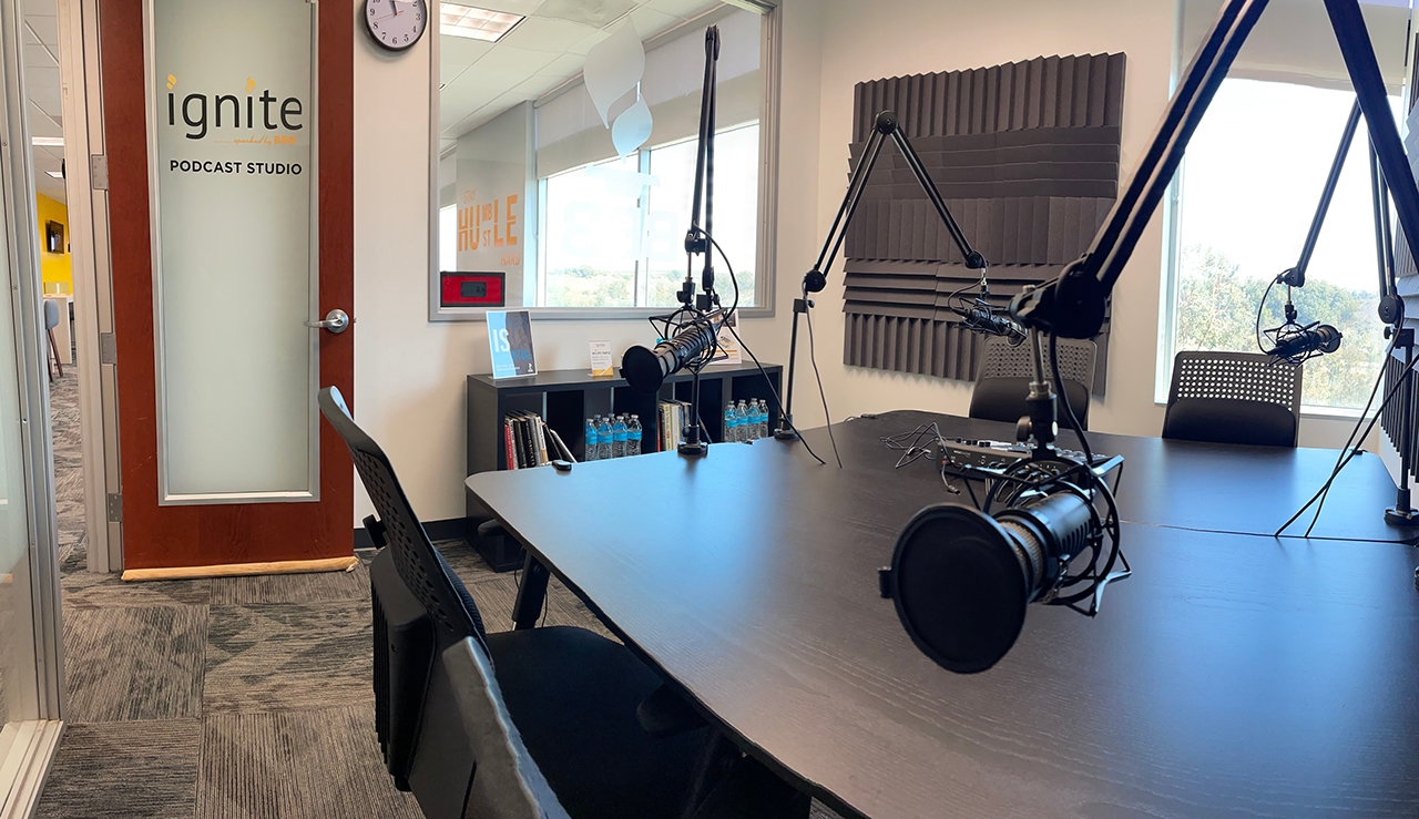 room with podcast recording equipment, a small table, and acoustic treatment on the walls