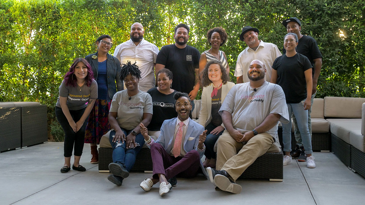 a diverse group of entrepreneurs posing for the camera on a patio